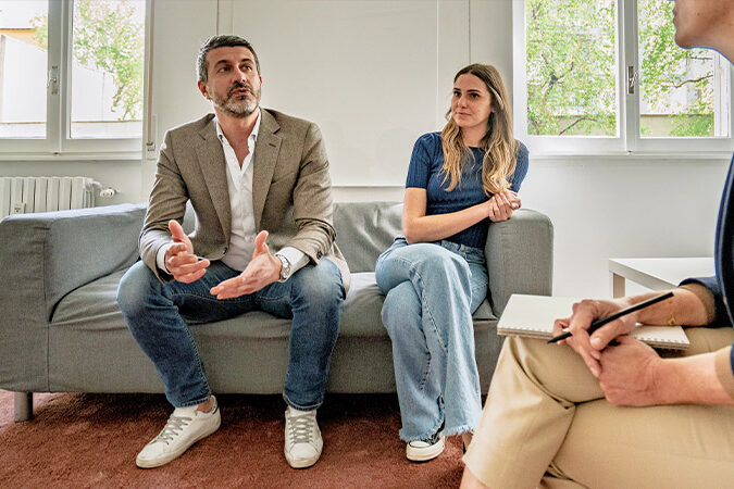 Wann ist Paartherapie sinnvoll Mann und Frau sitzen bei der Paartherapeutin und besprechen sich
