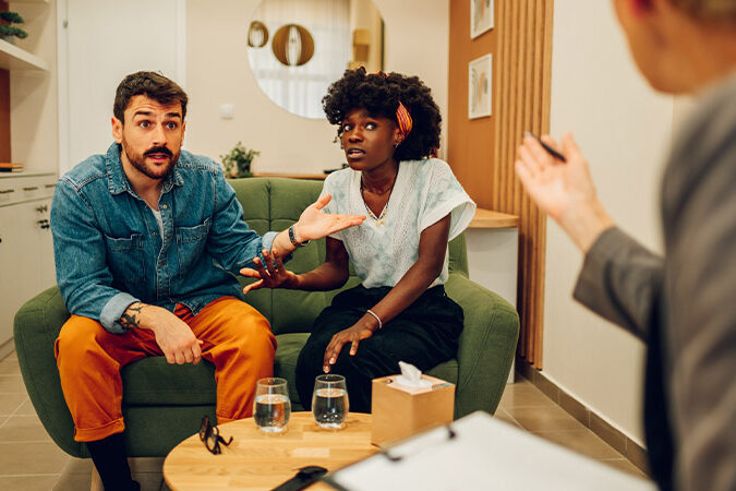 Warum streiten wir immer wieder über die selben Themen? junges Ehepaar im Gespräch bei der Paartherapie