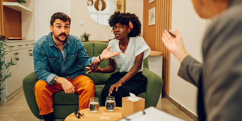 Warum streiten wir immer wieder über die selben Themen? junges Ehepaar im Gespräch bei der Paartherapie